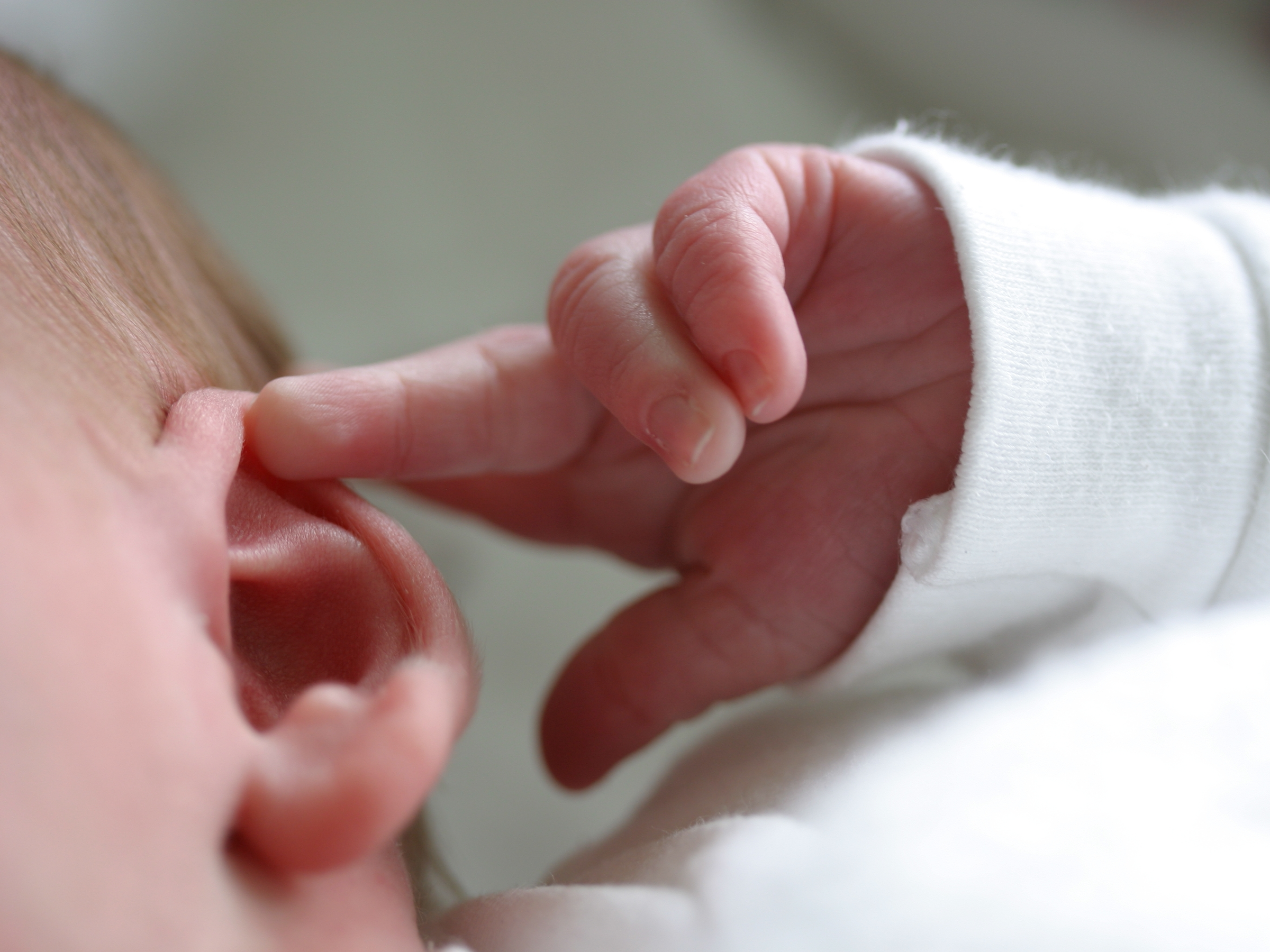 Почему ребенок теребит уши в грудничковом возрасте?